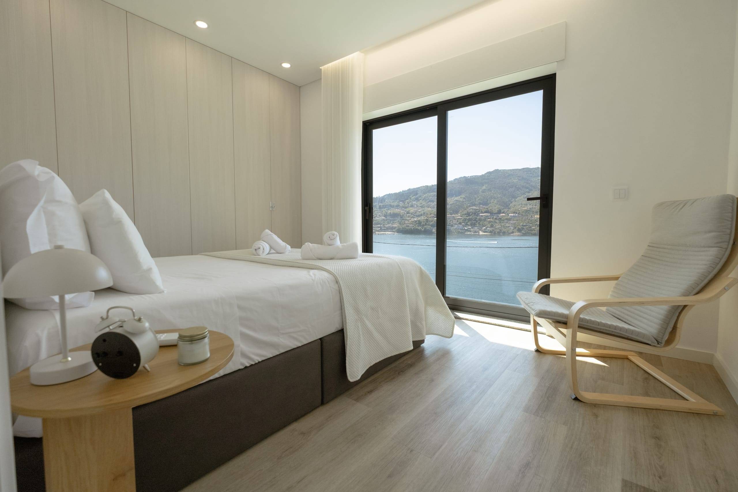 Double bedroom with armchair and view of the dam